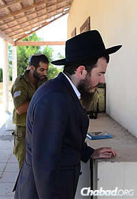 Chabad Rabbi Chaim Nochum Cunin, visiting from Chabad West Coast Headquarters in Los Angeles, prays with a soldier. (Photo: Meir Alfasi)