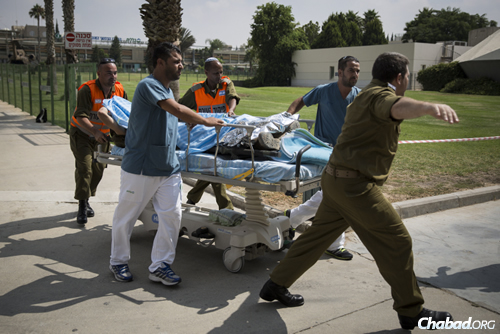 An IDF soldier wounded in combat in Gaza is led to the emergency room at Soroka hospital in Beersheva, after being evacuated from the field by helicopter. (Photo: Hadas Parush/Flash90)