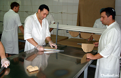 Workers at the Dnepropetrovsk matzah bakery rolling out traditional round matzahs. The Tiferes Hamatzos bakery employs 100 workers, among them exiles from the war-torn eastern regions of Donetsk and Lugansk.