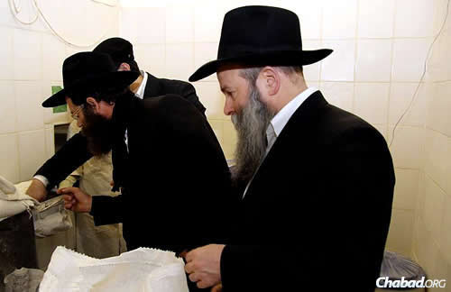 Ashkenazi inspects the flour, as Kaminezki looks on. (Photo: DJC.com.ua)