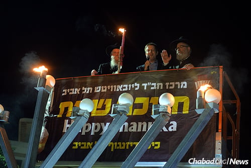 In the cherry-picker, from left: Rabbi Avrohom Shmuel Lewin , director of foeign affairs at Chabad of Tel Aviv; U.S. Embassy spokesman Geoffrey Anisman; and Rabbi Yossi Gerlitzky, head Chabad-Lubavitch emissary in Tel Aviv and director of Merkaz Chabad. ( Photo: Meir Alfasi)