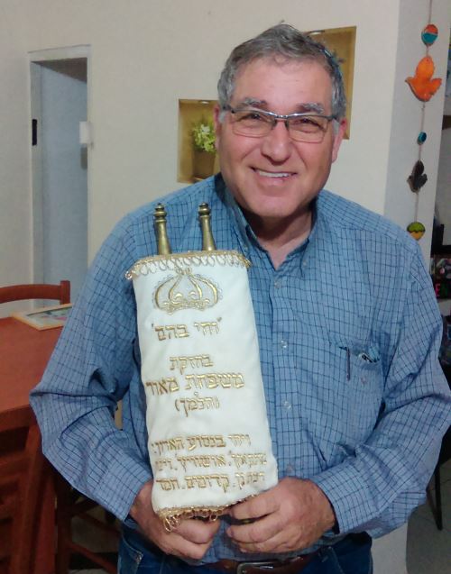 Yaakov Maor with the family Torah scroll smuggled into Auschwitz that he identified by its unusual copper staves.