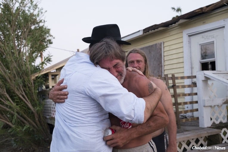 Chabad-Lubavitch Rabbi Naftoli Schmukler, left, of Corpus Christi, Texas, embraces and comforts Ed Flower, a business owner whose store was destroyed in Port Aransas, Texas, on Thursday, Aug. 31, 2017. (Credit: Verónica G. Cárdenas / Chabad.org)