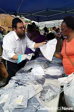 Rabbi Asher Federman, co-director of Chabad Lubavitch of the Virgin Islands, helps a woman locate an article of clothing.