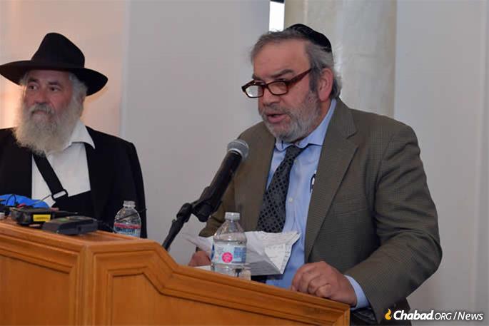 Dr. Howard Kaye speaks at the memorial as Rabbi Yisroel Goldstein looks on.