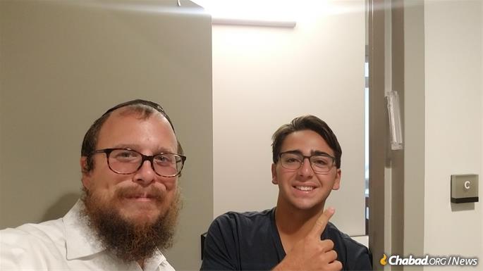 Rabbi Dov Wagner helps a USC student affix a mezuzah on his dormitory room. Sponsors hope the new legislation will inspire more Jewish people to respond to anti-Semitism with public affirmations of Jewish pride.