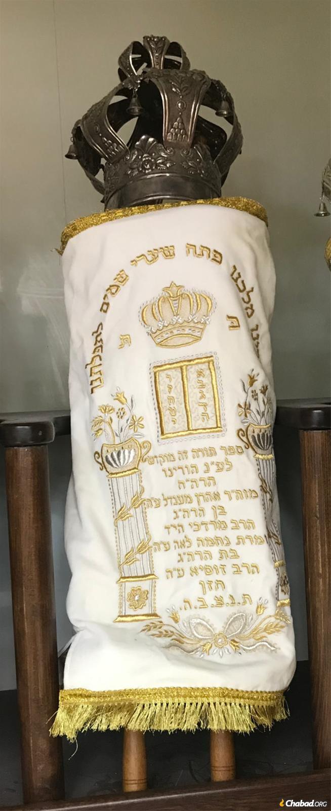 The Tula Torah in its white High Holiday mantle, dedicated to the memory of Rabbi Aharon and Nechamah Leah Chazan.