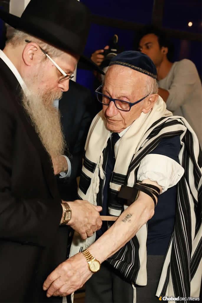 Le rabbin Dovid Weitman aide Andor Stern à mettre des téfilines pour la première fois. Stern est le seul survivant connu de l'Holocauste à être né au Brésil.