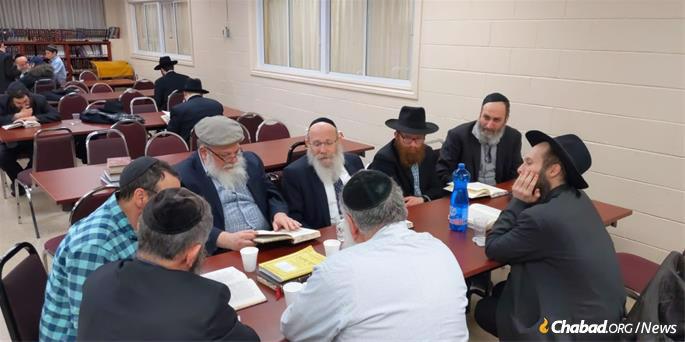 A group of men meet to study the weekly sichah with Rabbi Moshe Spalter.