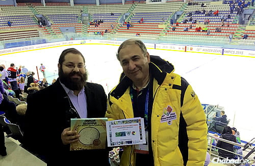 Rafael Pinchasov breaks for matzah at a hockey game, while he displays a book on the history of the Deaflympics.