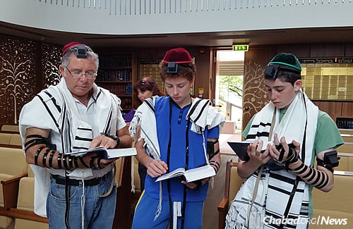 Wrapping tefillin in synagogue. The Jewish community in Estonia is getting ready for what has become a growing tradition there—participating in Tashlich, where in this case, Jews will symbolically cast their sins into the Baltic Sea.